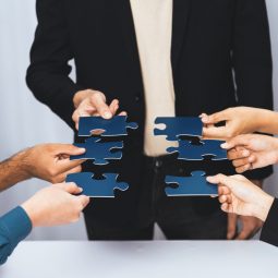 Business team joining jigsaw puzzle together symbolize group of business partnership and strong collective unity teamwork in problem solving solution for business success. Prudent